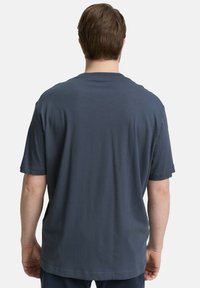 Diepblauw kortemouw t-shirt van zacht materiaal, met een ronde hals en een relaxed fit, met minimale details op de achterkant.