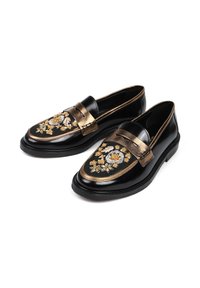 Czarne skórzane mokasyny z złotymi akcentami, haftowane kwiatowe detale w kolorze żółtym i białym, zaokrąglony czubek, płaska podeszwa i dekoracyjna taśma na wierzchu buta.