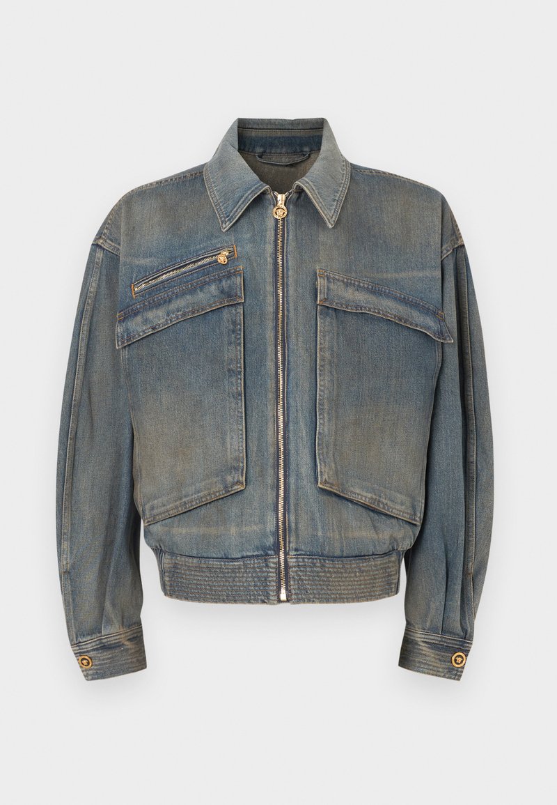 Jeansjacke in Mittelblau mit einem Reißverschluss vorne, zwei frontalen Taschen und geripptem Saum. Mit klassischem Kragen und goldfarbenen Hardware-Details.