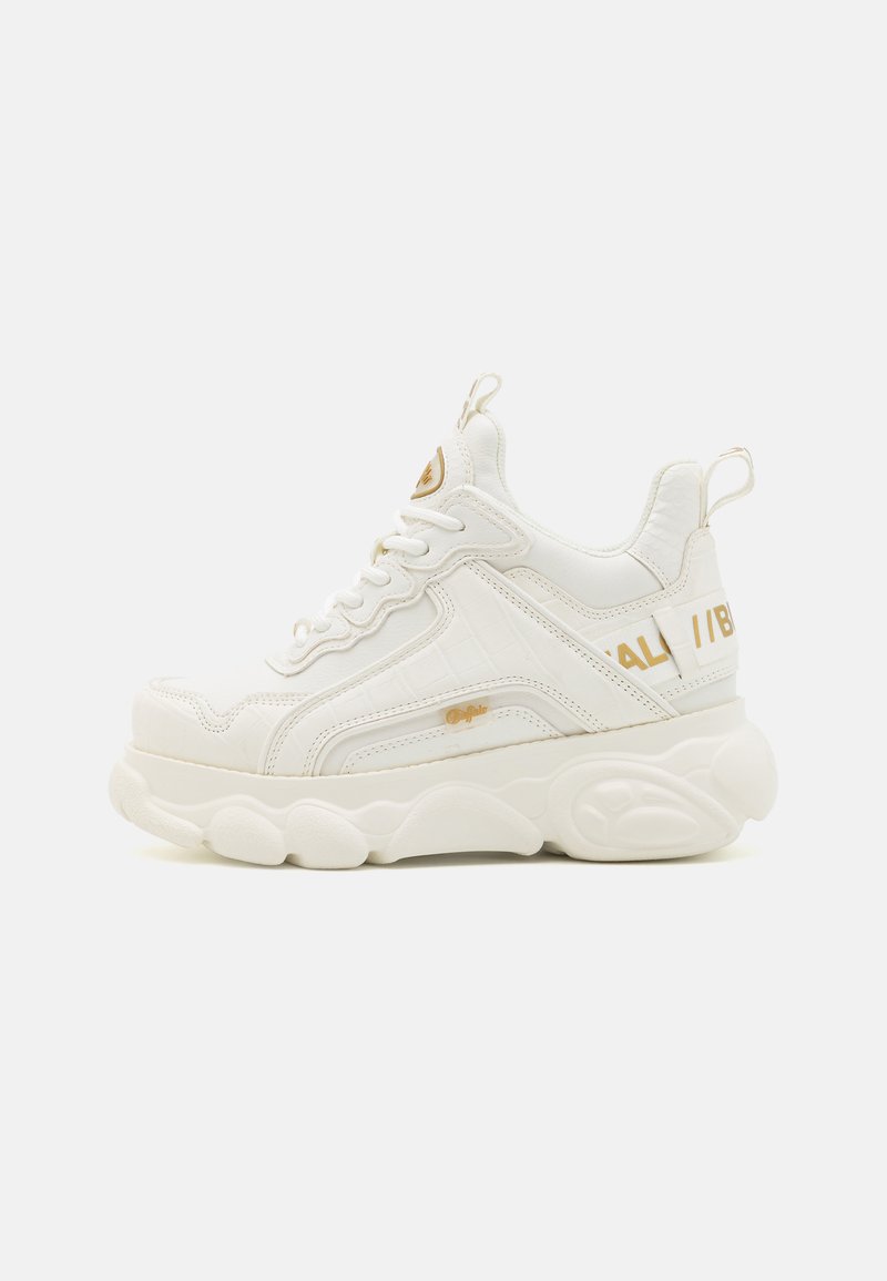 Masywne białe sneakersy z teksturowanym wierzchem z sztucznej skóry, złotymi akcentami oraz grubą, amortyzowaną gumową podeszwą o charakterystycznym kształcie.