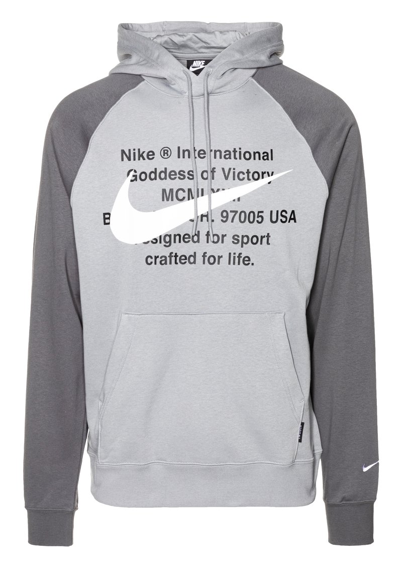 Grå huvtröja med mörkgrå raglanärmar, framficka i kengurustil, framträdande vitt Nike-logotyp och tryckt text på bröstet.