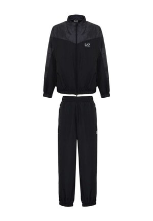 Tuta nera composta da una giacca con zip e colletto alto e pantaloni con vita elasticizzata. Presenta un logo sulla giacca e sui pantaloni.