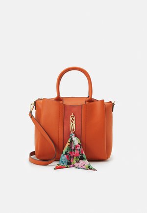 Sac à main en cuir orange avec poignées supérieures, bandoulière amovible, breloque monogramme dorée et foulard fleuri coloré attaché à l'avant.