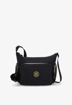 Bolso de hombro de nylon negro con cremalleras doradas, bolsillo delantero y logo circular. Presenta un llavero con pom-pom desmontable y correa ajustable.