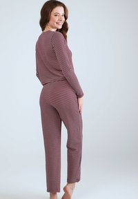 Gestreepte pyjama set in bordeauxrood en crèmewit, met lange mouwen en aansluitende broek met een comfortabele pasvorm, zachte textuur en een minimalistisch ontwerp.