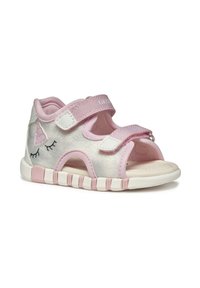 Sandali per bambini rosa con un upper lucido argento, due cinturini in velcro e un design di unicorno che presenta un orecchio e ciglia sul lato.