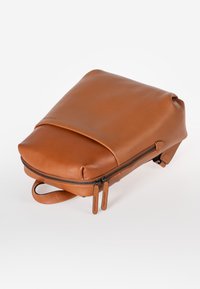 Zaino in pelle marrone con un design elegante, ampia chiusura con zip e pattina superiore. Presenta una maniglia per il trasporto e un marchio sottile sulle linguette delle zip.