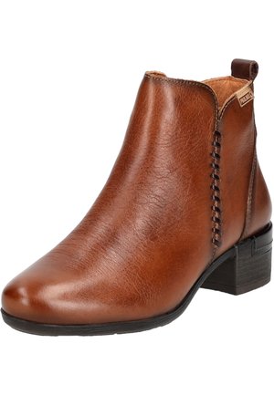 Botte chevillère en cuir marron avec un bout pointu, finition texturée, détail de couture sur le côté et un petit talon carré.