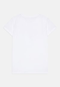 Camiseta blanca de manga corta hecha de tela de algodón suave. Diseño sencillo de cuello redondo sin patrones ni acentos. Costuras planas y bordes limpios.