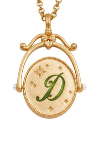 Zlatý prívesok na retiazke s oválnym tvarom, zeleným písmenom "D", gravírovanými hviezdami a perlami po bokoch.