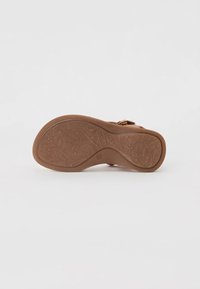 Brun sandaler med en texturerad gummisula som har blommönster och en formad fotbädd. Justerbar rem för en säker passform.