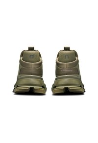 Zapatillas deportivas de color verde oliva con un upper texturizado, talón reforzado, logo en contraste y una suela estriada para mayor tracción.