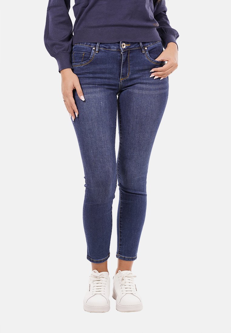 Jeans in denim blu scuro con una vestibilità slim e lunghezza alla caviglia. Le caratteristiche includono tasche frontali, chiusura con bottone e una leggera scoloritura per texture.