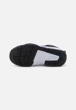 Czarno-biała podeszwa tenisówki z teksturowanej gumy. Zawiera niebieski akcent i wyraźny wzór bieżnika zapewniający przyczepność. Wzmocniony heel oraz wsparcie dla łuku stopy.