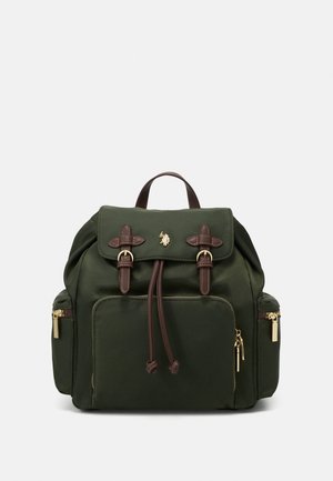 Sac à dos vert foncé avec des sangles en cuir marron, des détails de fermeture éclair dorée, une poche avant, des poches latérales et un petit logo de cheval doré sur le rabat.