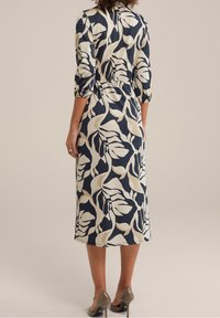 Blumendruck, marineblaues und kremfarbenes Midi-Kleid mit Dreiviertelärmeln, tailliertem Schnitt und strukturiertem Stoff. Mit einem Kragen akzentuiert.