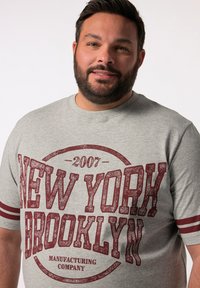 Szara koszulka z krótkim rękawem z vintage'owym, czerwonym nadrukiem z napisem "NOWY JORK 2007 BROOKLYN" oraz paskowanymi akcentami na rękawach.