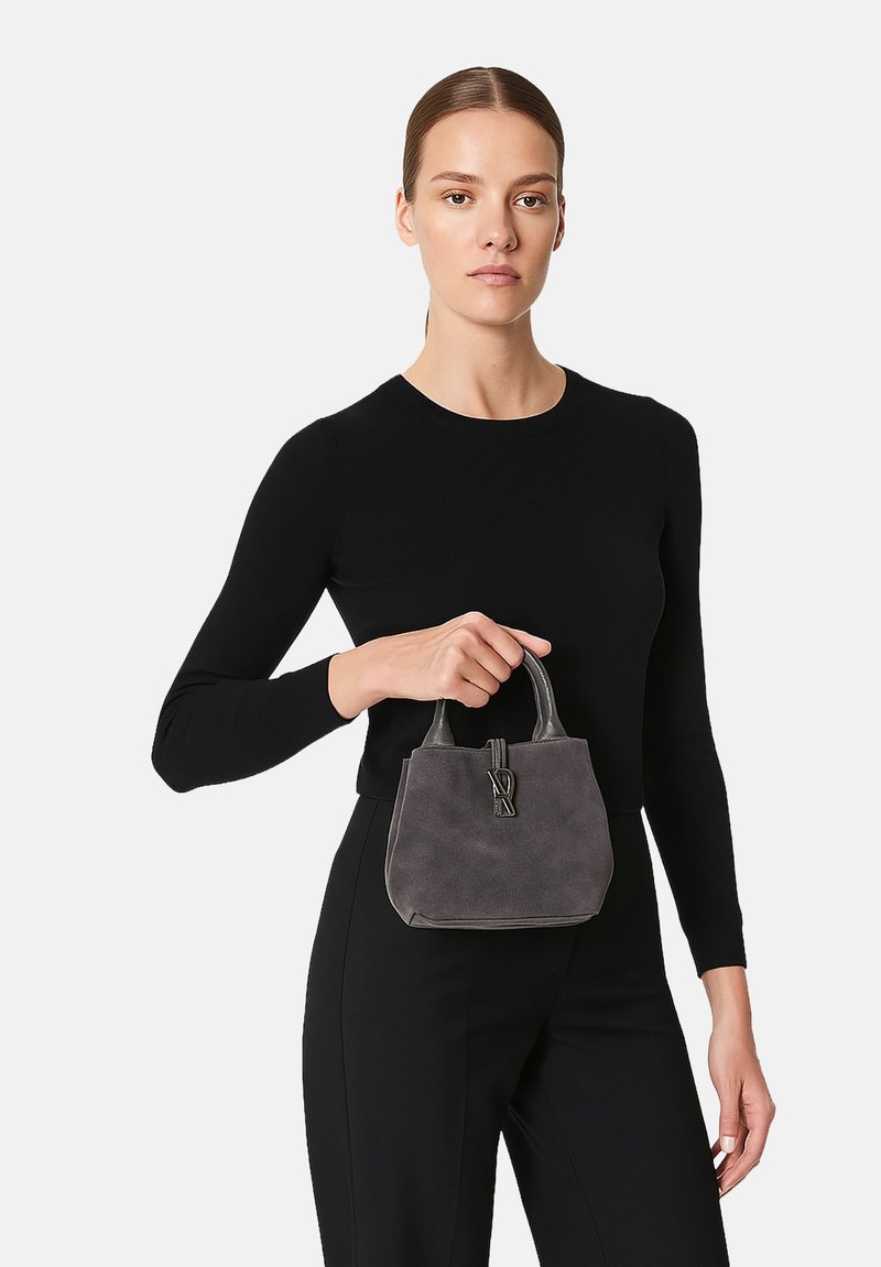 Borsa in suede grigio con design strutturato, doppi manici e un accento decorativo del logo. Texture liscia con forma compatta e rettangolare.