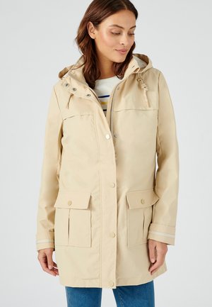 Helle beige wasserdichte Jacke mit Kapuze, vorn mit Druckknopfverschluss, zwei Klappentaschen und gestreiftem Akzent an den Bündchen. Aus glattem Stoff gefertigt.