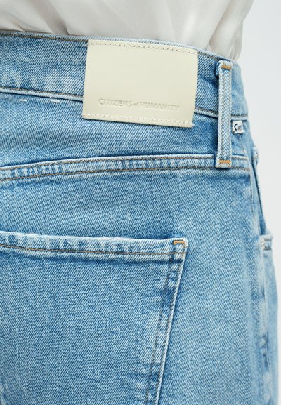 Jeans din denim de culoare bleu deschis, cu o etichetă din piele pe talie, imprimată cu "CITIZENS of HUMANITY." Cusături expuse și două buzunare posterioare.