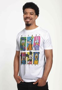 Biała bawełniana koszulka z nadrukiem graficznym przedstawiającym postaci z kreskówek w kolorowych kwadratowych ramkach, w tym Myszka Miki i jego przyjaciół, wydrukowanym z przodu.