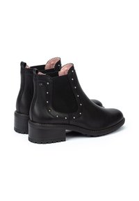Botines de cuero negro con acentos rosas, paneles laterales elásticos, tachuelas de plata y un tacón grueso. Textura suave y diseño de punta redondeada.