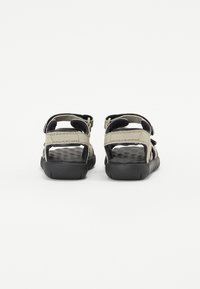 Achteraanzicht van grijze en zwarte sandalen met verstelbare bandjes en gestructureerde zolen. Kenmerkt een open ontwerp en veilige gespbevestigingen.