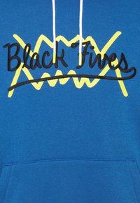 Felpa blu con cappuccio, caratterizzata da un vistoso testo ricamato in nero "Black Fives" con accenti zigzag gialli. Include lacci bianchi e tasca frontale.