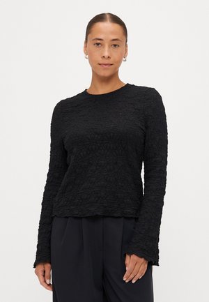 Zwart langemouwen top van textuurmateriaal met een bloemenpatroon, met een ronde halslijn en geschulpte manchetten.