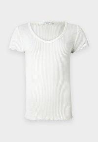 Valkoiset ribbed-hihattomat paita, jossa on V-kaula-aukko ja aaltoilevat reunat, kevyt ja puoliksi läpikuultava neulekangas.