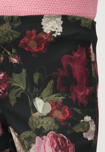 Kvetinové nohavice s čiernym podkladom a žiarivými červenými, ružovými a bielymi kvetmi, doplnené zelenými listami. Mäkká tkanina s detailnými motýľovými ozdobami.