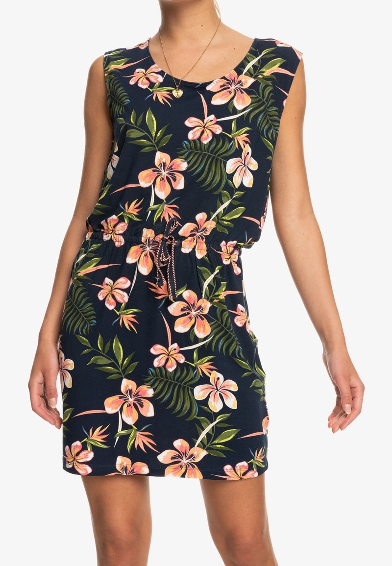 Robe sans manches bleu marine avec imprimé floral rose et orange et feuilles vertes, cintrée à la taille avec un cordon, portée par une personne debout.