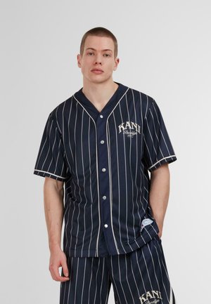 Navy blue striped short-sleeve shirt with a button-down front, featuring a circular logo and contrasting white piping along edges.