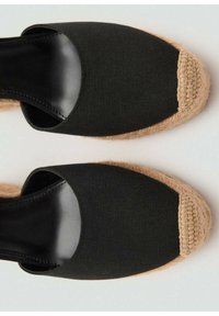 Schwarze Leinenschuh-Espadrilles mit runder Zehenpartie, ausgestattet mit einem gewebten Jute-Besatz und einem glatten schwarzen Innenfutter.