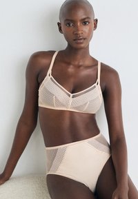 Bra and high-waisted brief set in light beige, featuring mesh panels, lace accents, and adjustable straps with a smooth finish.