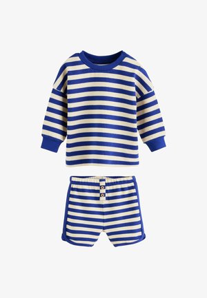 Tenue pour tout-petit avec haut à manches longues et short, présentant des rayures horizontales bleues et crème et des poignets côtelés bleus.