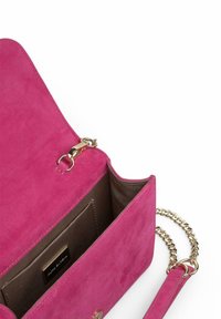 Bolso de ante rosa con un cierre de hardware dorado, correa de cadena y una textura suave. El interior cuenta con un forro marrón y un pequeño bolsillo.