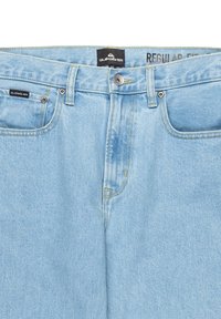 Vaqueros de mezclilla azul claro con corte regular, cierre de botón, bolsillos delanteros y laterales, y costuras amarillas en contraste.