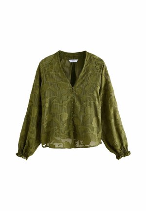 Blouse manches longues vert olive avec motif de dentelle florale, boutons recouverts de tissu sur le devant, et poignets élastiqués.
