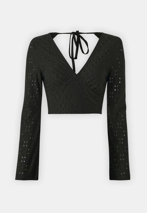 Must mustreblus, millel on pikad varrukad, V-kaelus ja sidumisvõimalus seljaosas. Tekstureeritud kangas dekoratiivsete lõigetega kogu ulatuses.