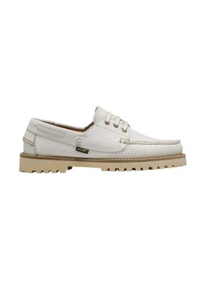 Chaussure bateau blanche en cuir à lacets avec semelle texturée et étiquette latérale, montrée de profil sur fond blanc.