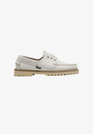 Chaussure bateau blanche en cuir à lacets avec semelle texturée et étiquette latérale, montrée de profil sur fond blanc.