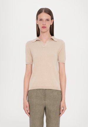 Beige polo shirt met korte mouwen en een V-hals, met een kraagontwerp, gemaakt van een zachte stof, gecombineerd met groen en zwart geruite broek.