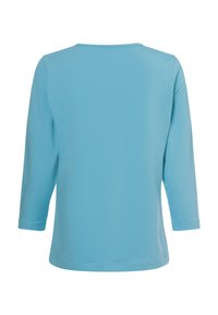 Himmelblaues Longsleeve mit lockerer Passform, Rundhalsausschnitt und Dreiviertelärmeln. Weicher Stoff mit glatter Textur, ohne Muster.