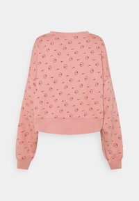 Ljust rosa kortärmad sweatshirt med rund halsringning, långa ärmar och ett upprepande cirkulärt mönster i mörkröd, med varumärkeslogotyper.