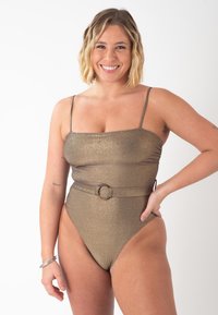 Maillot de bain une pièce en or métallique avec des bretelles fines, un décolleté carré, des côtés froncés et un détail ceinture avec une boucle circulaire.