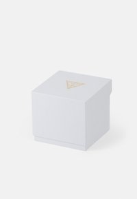Hvid firkantet kasse med en struktureret overflade og et gyldent trekantet logo på den ene side. Designet har et låg, der sidder i niveau med bunden.