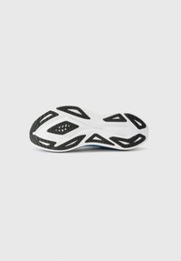 Shoe outsole with a textured black rubber surface, featuring white accents, distinctive cutouts, and a sleek design for improved grip.