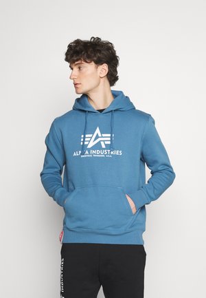 Blauwe hoodie van katoen, met een voorzak in kangoeroestijl, witte logo-print en ribgebreide manchetten. Zwarte broek met witte branding.