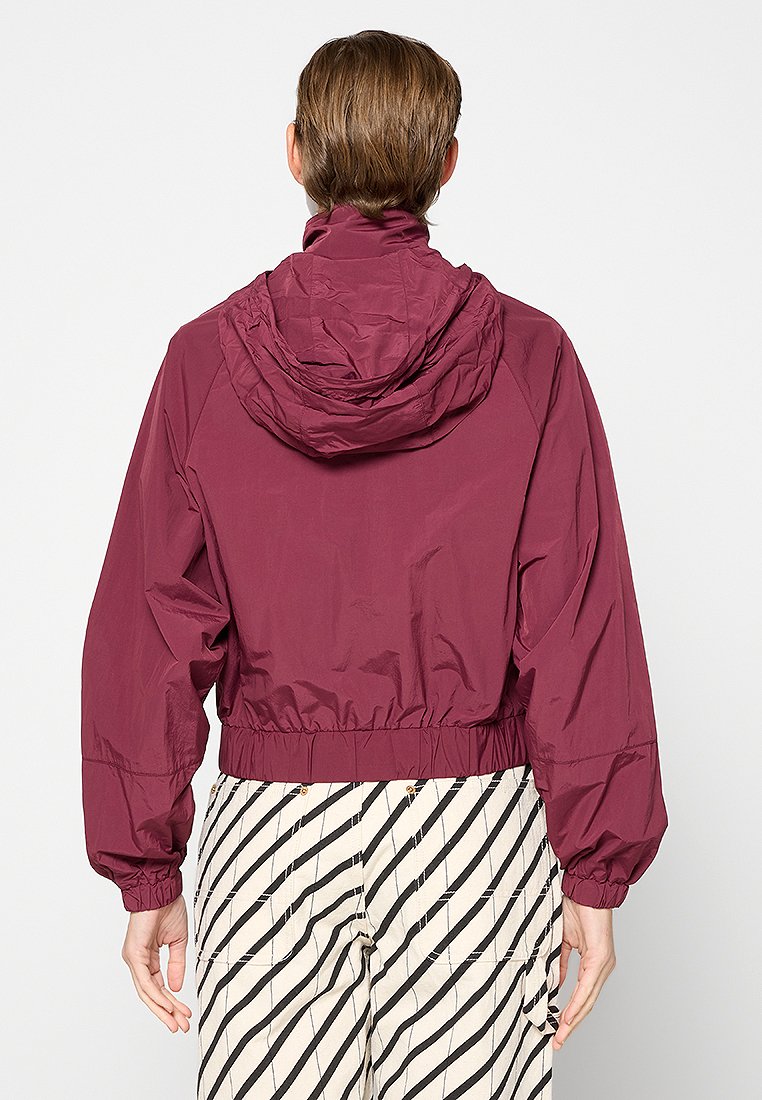 Maroon windbreaker jas met een capuchon, elastische tailleband en een relaxte pasvorm. Lichtgewicht materiaal met een gladde textuur en geen zichtbare versieringen.